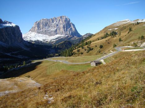 View of Sassolungo peak ( known also as Langkofel) and alpine road leading to Gardena pass, Dolomites, Italy