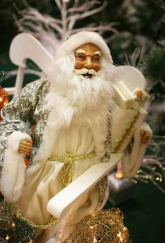 Toy Santa Claus with gifts on white sledge