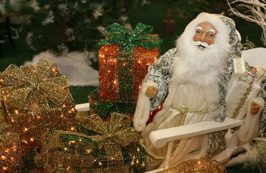 Toy Santa Claus with gifts on white sledge