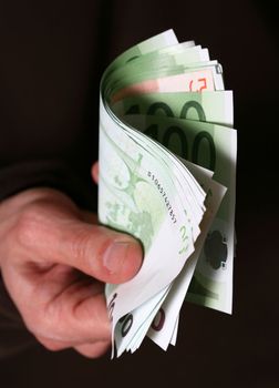 Hand giving Euro banknotes money