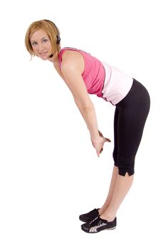 A blond female fitness instructor wearing a pink top and black spandex pants. She is bending forward in a streach.