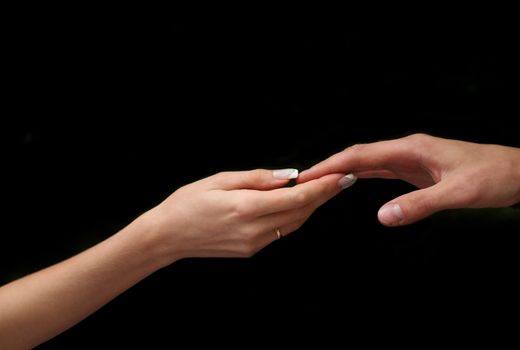 Man's and female hand on a black background