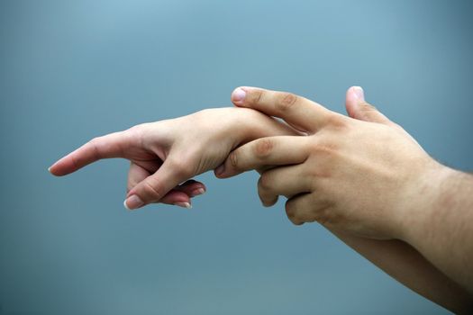 Man's and female hand on a background of the sky