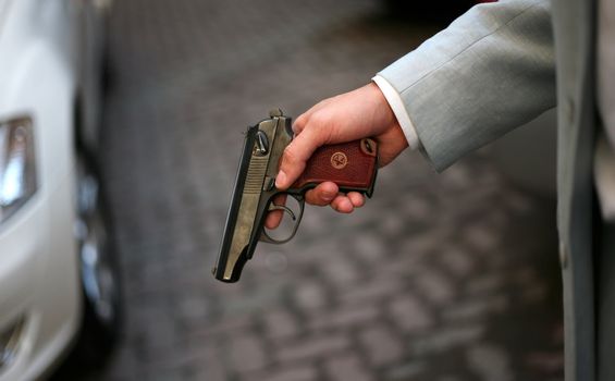 The person in a grey suit with a pistol