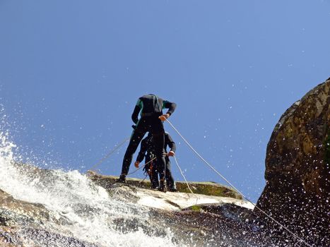 Men preparing to descend waterfall