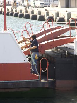 Crew member working on departer of ferry-boat, raising platform 