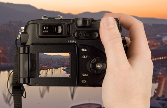 Digital Camera photo in a hand isolated on withe background. lcd screen and background can be easily edited