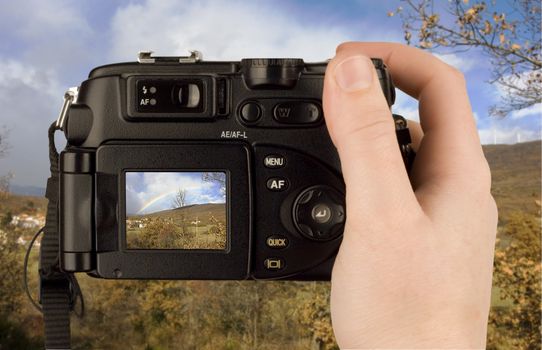 Digital Camera photo in a hand isolated on withe background. lcd screen and background can be easily edited