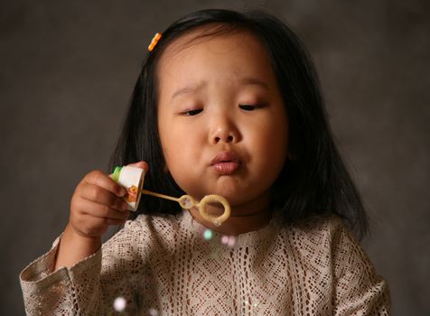 The small Korean girl and soap bubbles
