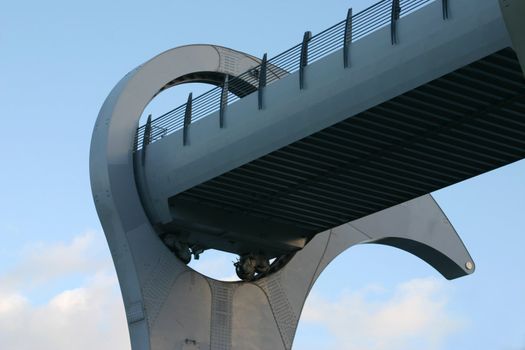 Detail of Falkirk Wheel (rotating boat lift for canal boats between the Forth and Clyde Canal and the Union Canal, Scotland, UK, against cloudy sky.