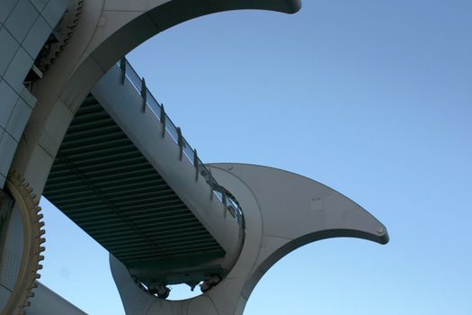 Detail of Falkirk Wheel (rotating boat lift for canal boats between the Forth and Clyde Canal and the Union Canal, Scotland, UK, against blue sky.