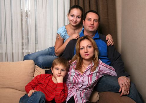 Mum, daddy and two children on a sofa