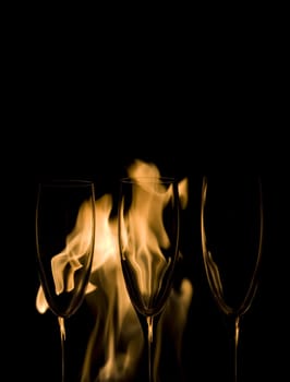 Three Crystal glasses and fire isolated on black  