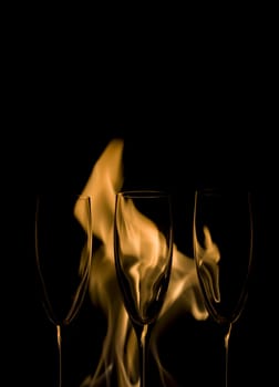 Three Crystal glasses and fire isolated on black  