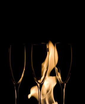 Three Crystal glasses and fire isolated on black  