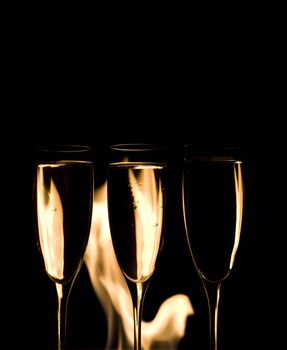 Three Crystal glasses and fire isolated on black  