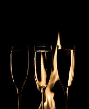 Three Crystal glasses and fire isolated on black  