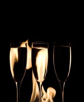 Three Crystal glasses and fire isolated on black  