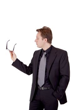 A young business man is holding his glasses while presenting something