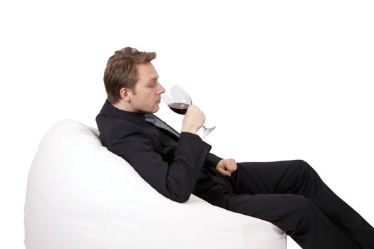 A young business man is enjoying a glass of wine after work