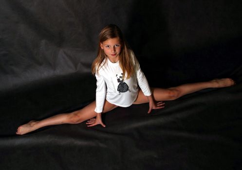 Young the girl - teenager does sports exercise in studio