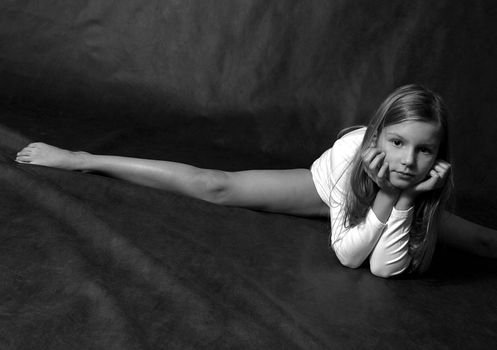 Young the girl - teenager does sports exercise in studio. b/w