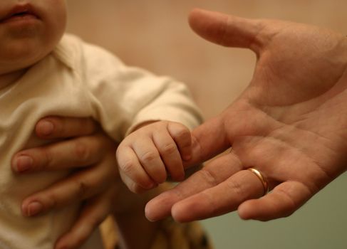 The image of hands of parents and the kid