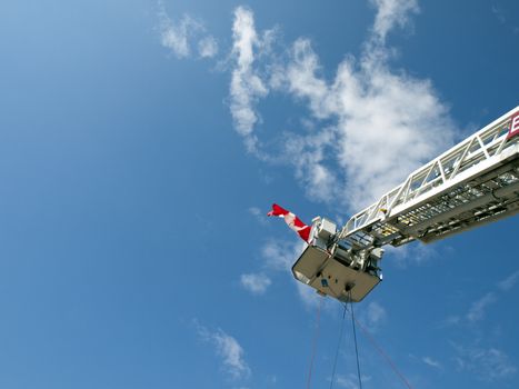 Fire engine ladder extending into a blue sky.