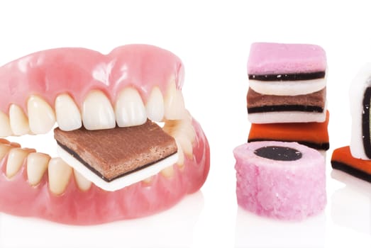 Dentures with candy isolated on a white background.