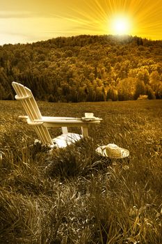 Relaxing on a summer chair in a field of tall grass at sunset