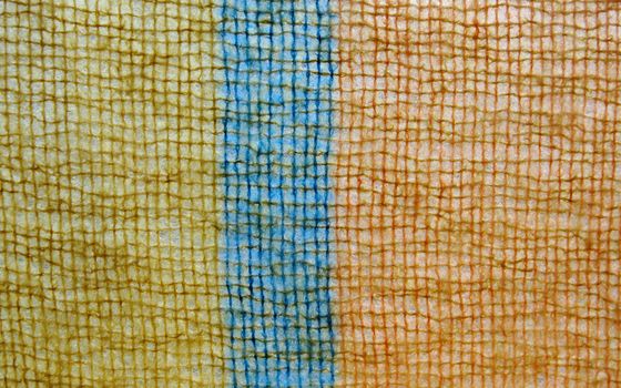 detail of a fuzzy orange, dark yellow and blue knit, suitable for background use