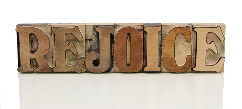 the word 'rejoice' in old wood type isolated on white with a reflection