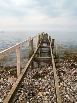 Dramatic beautiful seascape with an old wooden footbridge