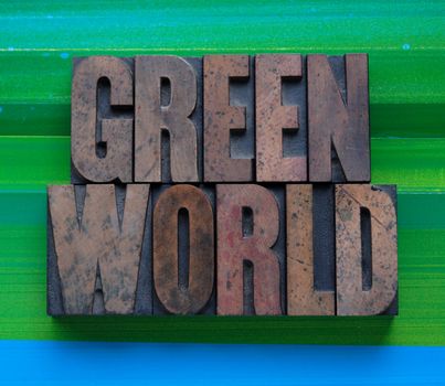 the words 'green world' in letterpress wood type on a green and blue background