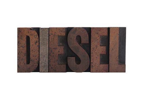 the word 'diesel' in old, ink-stained wood letters isolated on white