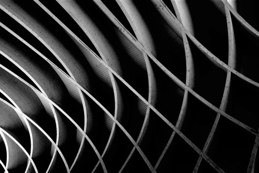 Dark black and white image of an abstract wooden architectural element.
