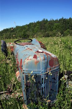 An old abandoned tractor left to rot in a field.