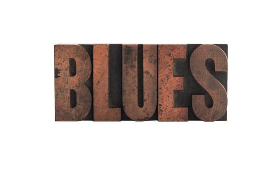 the word 'blues' in old, ink-stained wood letters isolated on white