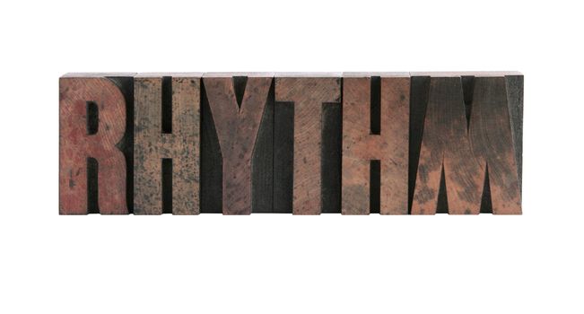 the word 'rhythm' in ink-stained wood letters isolated on white