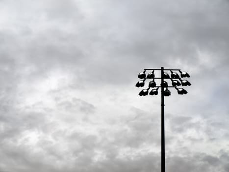 Football field flood lights on a stormy spring sky.