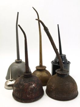 A group of oil cans, obsolete and modern, studio isolated over a white background.
