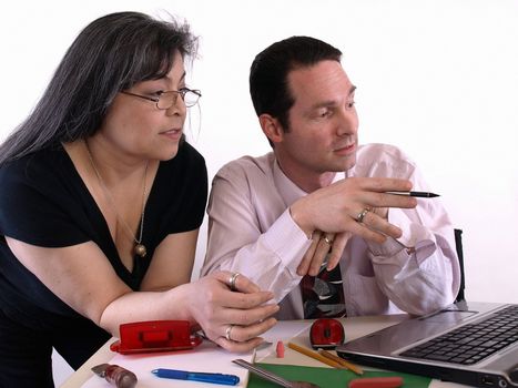 A male and female working together in the office at the computer. Isolated against a white background.