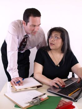 A male and female working together in the office at the computer. Isolated against a white background.