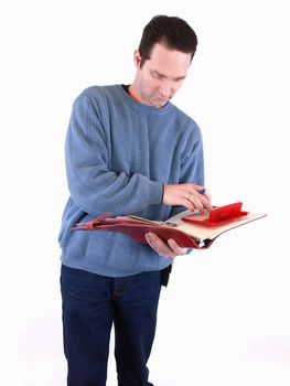 An adult male in blue checks over some figures in a binder. Isolated on a white background.
