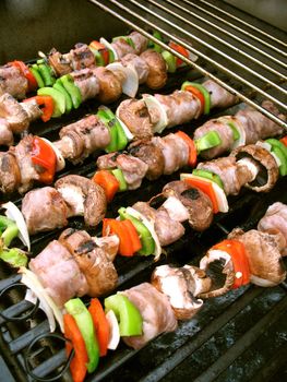 Sausage shish kebabs on skewers, cooking on the grill.  