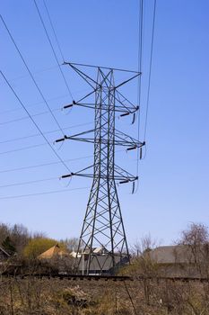 Some high power lines over a bright blue sky.