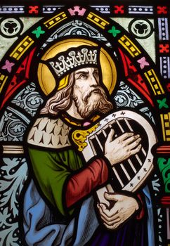 detail of victorian stained glass church window in Fringford depicting King David, the author fo the psalms in the Old testament with a hand harp