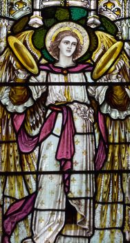 detail of victorian stained glass church window in Fringford depicting a typical victorian angel with cymbals in his hands