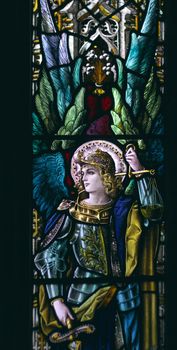 detail of victorian stained glass church window in Fringford depicting a typical victorian angel with a sword in his hands