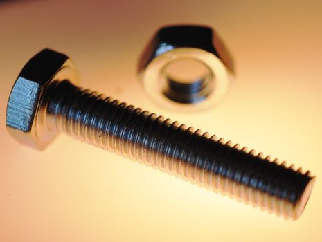 A close-up photograph of a hex head screw and accessory.